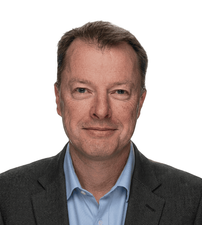 Head-and-shoulders portrait of a smiling man in a dark blazer and light blue shirt, suitable for a professional bio.