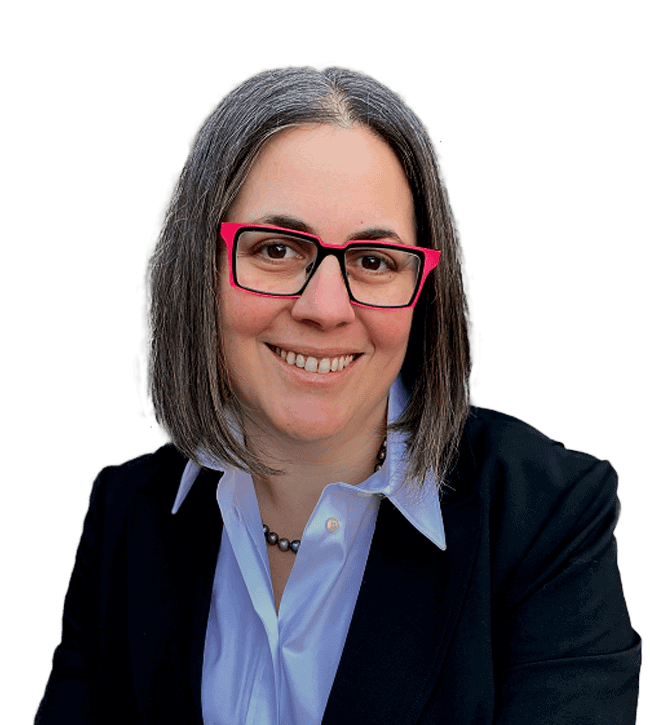 Smiling professional woman with shoulder-length gray hair, pink-framed glasses, wearing a light blue shirt and dark blazer.